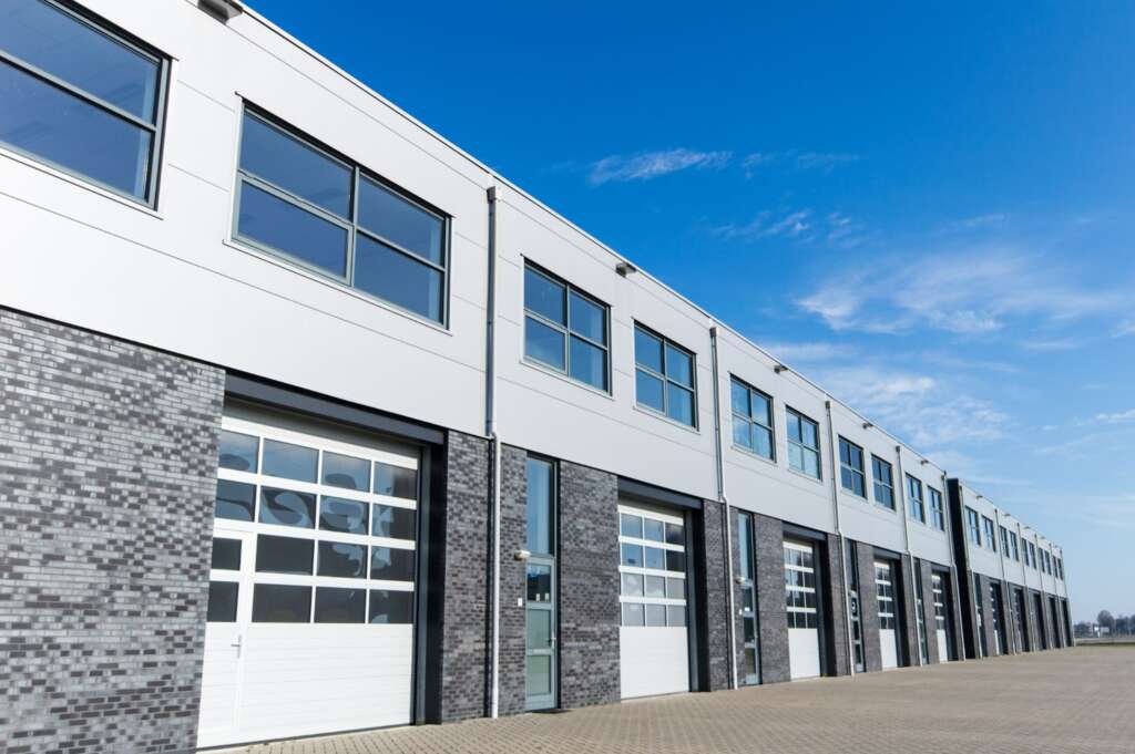 Modern warehouse with multiple garage doors and windows.