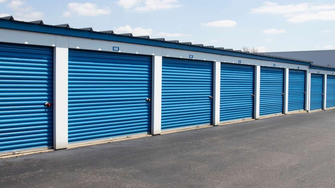 Blue self-storage units arranged in a parking lot showcasing a neat and organized storage facility