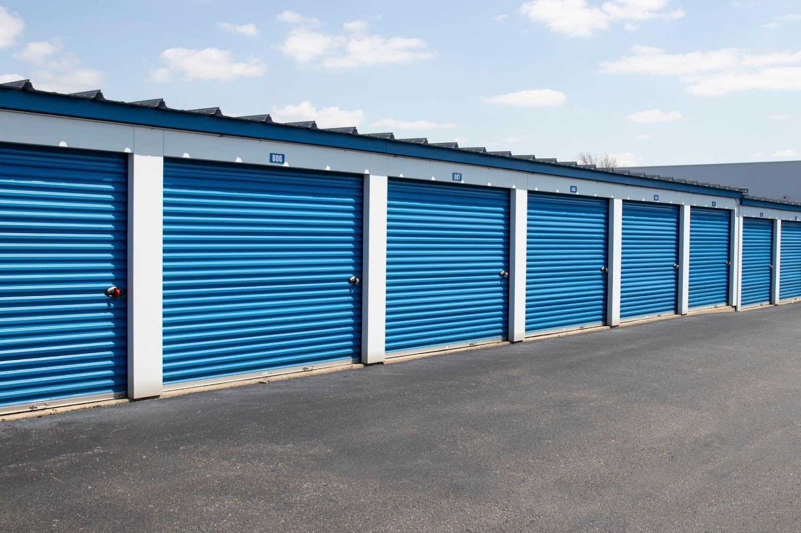 Blue self-storage units arranged in a parking lot showcasing a neat and organized storage facility