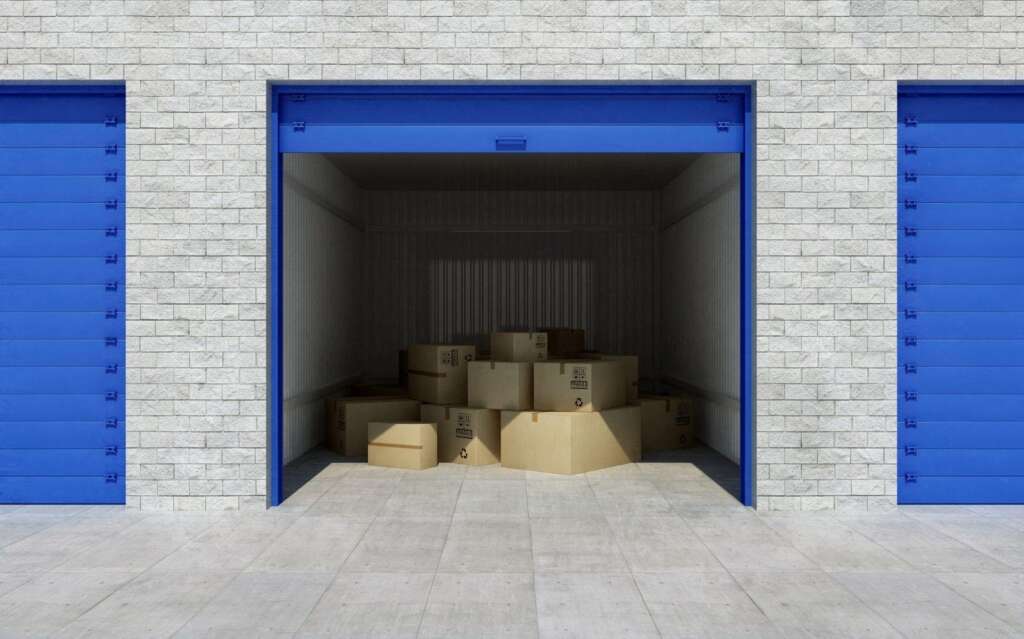 Open storage unit with blue doors and a stark gray brick exterior