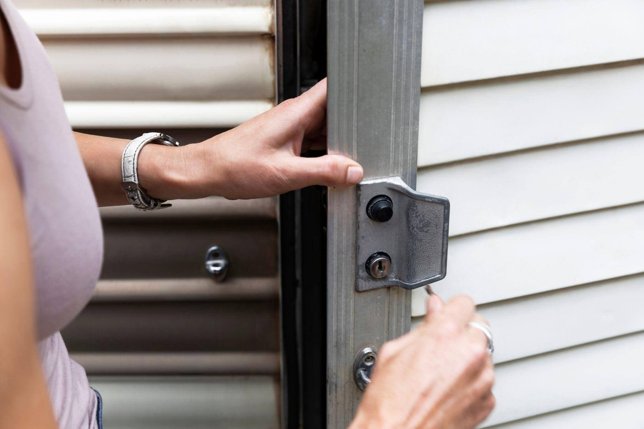 A woman is opening the front door of a house revealing the interior space beyond